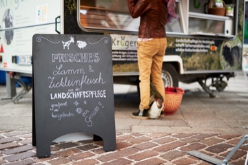 Verkaufsstand Kr&uuml;ger-Land auf dem Wochenmarkt in Sindelfingen. Mit einem Verkaufsschild "Frisches Lamm- und Ziegenfleisch aus den Landschaftspflege"